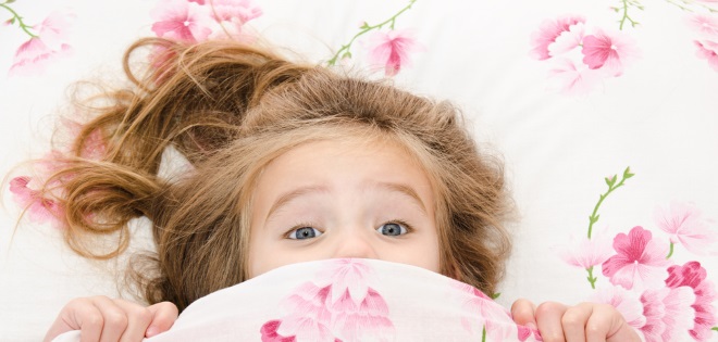 Scared girl in bed suffering from night terrors