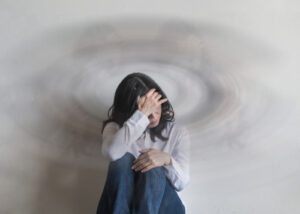 Young woman dizzy and sitting down