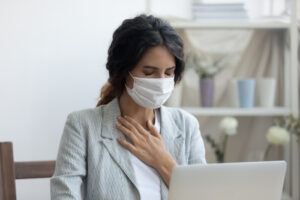 woman wearing mask while sitting at computer 