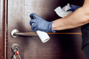 person disinfecting door handle