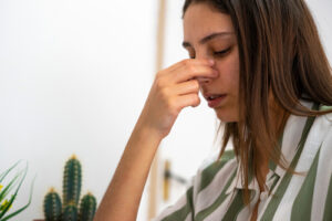 woman holding her nose