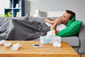 sick man laying on couch 